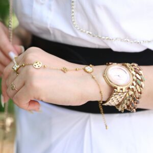 Close-up of a woman's wrist with elegant gold jewelry, showcasing style and luxury.