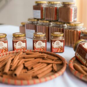 High-quality organic cinnamon sticks and powder beautifully arranged in glass jars and baskets for presentation.
